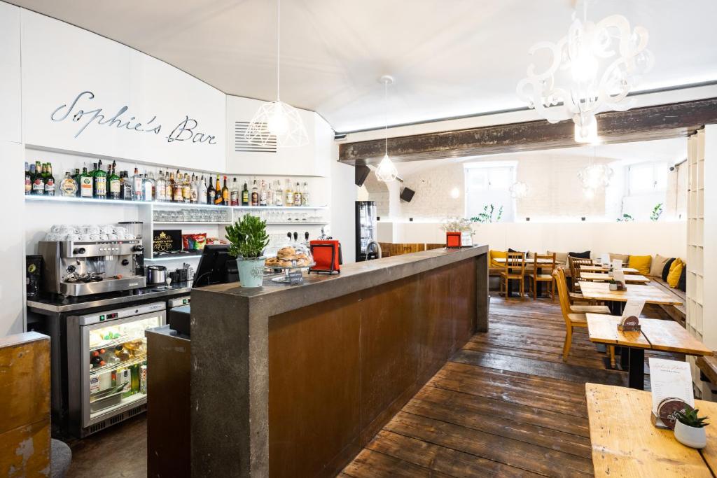 a restaurant with a bar and tables and chairs at Sophie's Hostel in Prague