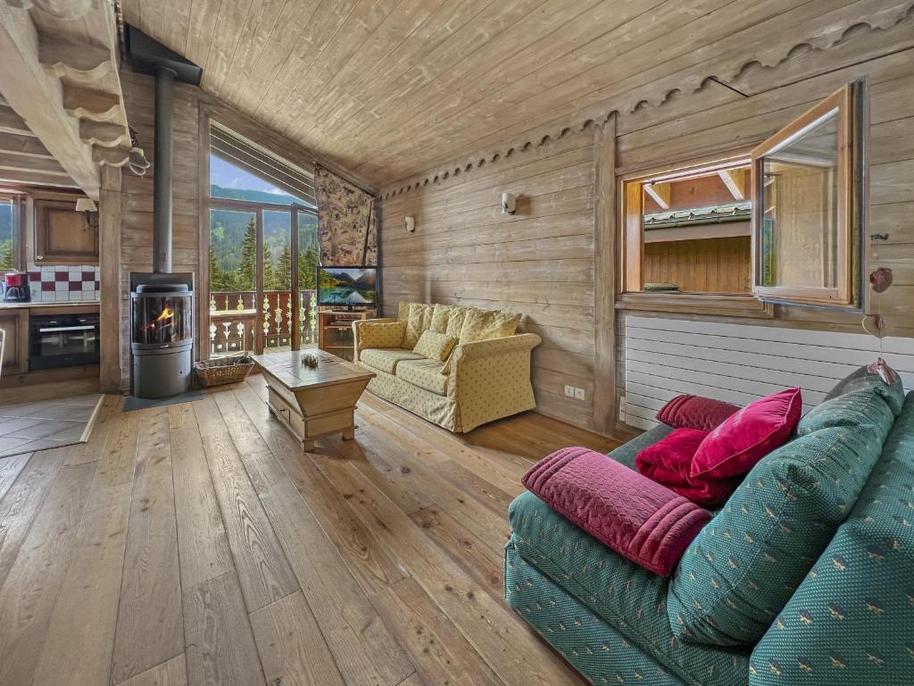 a living room with a couch and a stove at Duplex 7 pers proche base de loisirs Carroz (ACL06) in Les Carroz d'Araches