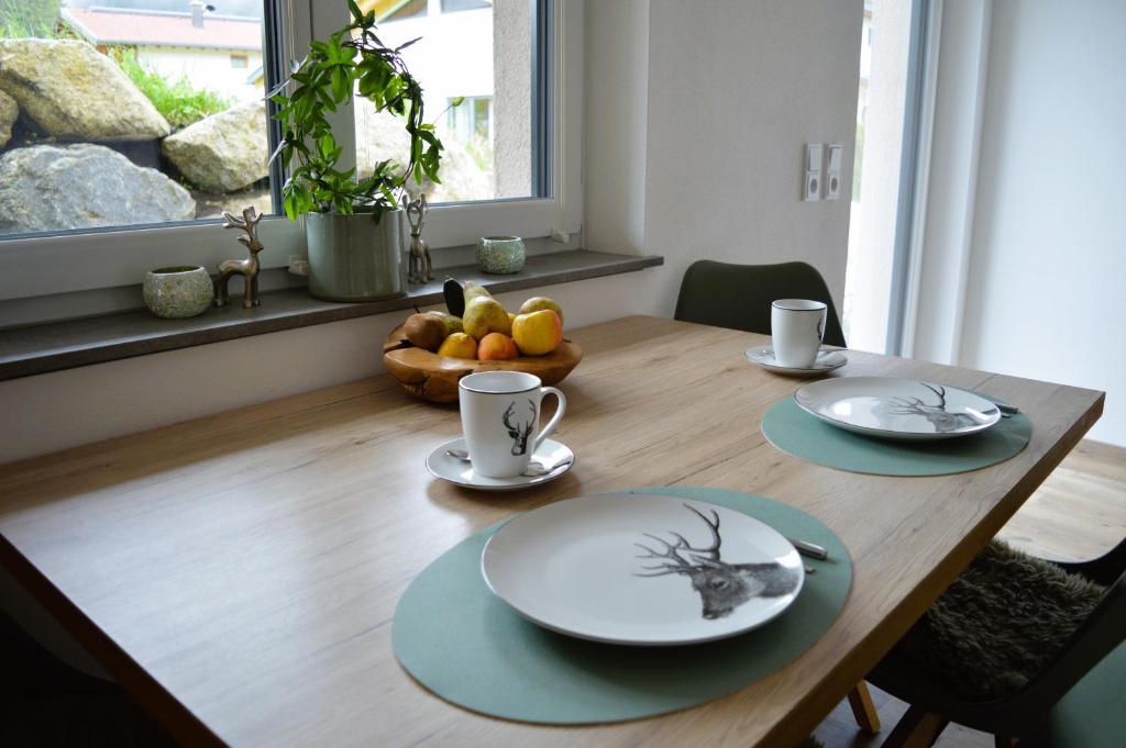 un tavolo in legno con piatti e tazze e un cesto di frutta di Alpenflair a Berwang
