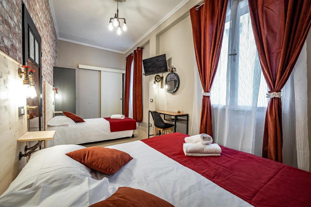 pokój hotelowy z 2 łóżkami z czerwonymi zasłonami w obiekcie HOTEL VENETO Centro Storico di Firenze we Florencji