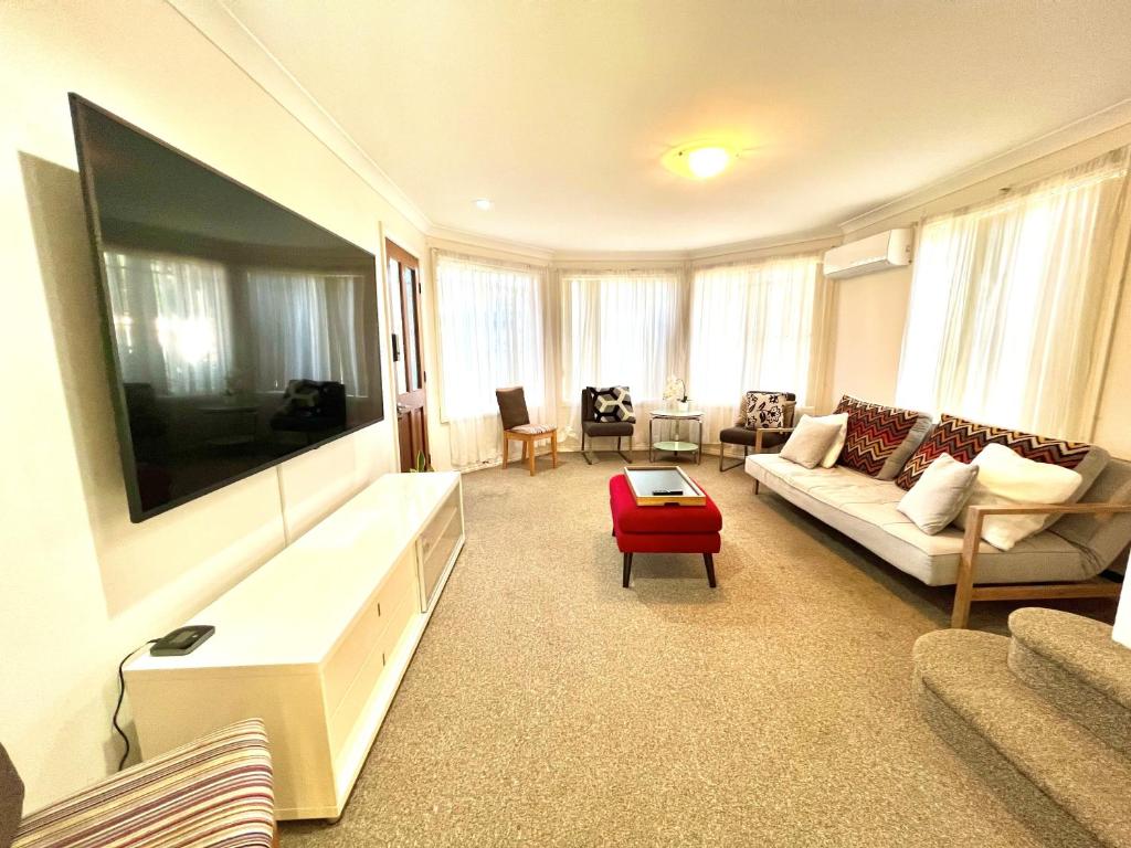 a living room with a large flat screen tv at 3 Bedroom Town house near Gosford CBD Sleeps 6 plus in Gosford