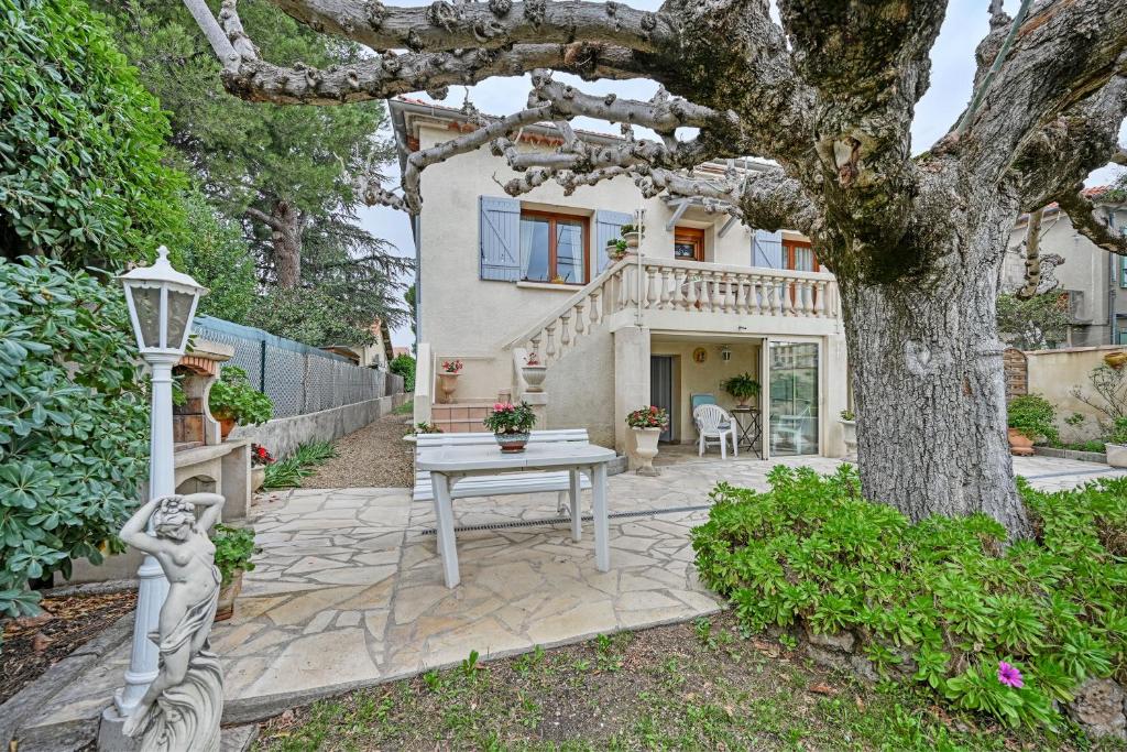 a house with a table and a tree at Appartement Chez Marie Thrse in Le Pontet