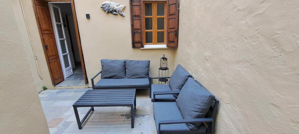 twee blauwe stoelen en een tafel op een patio bij The Retreat in the heart of Old Town Rhodes in Rhodos-stad