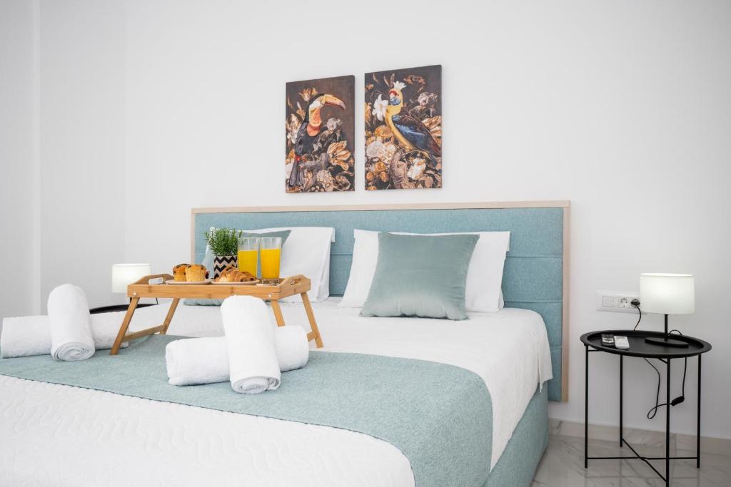 Schlafzimmer mit einem großen Bett mit blauem Kopfteil in der Unterkunft Athinais Suites in Hersonissos