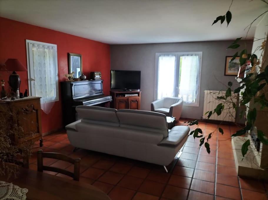 a living room with a couch and a television at Chez Coco maison au coeur du parc régional du Quercy in Issendolus