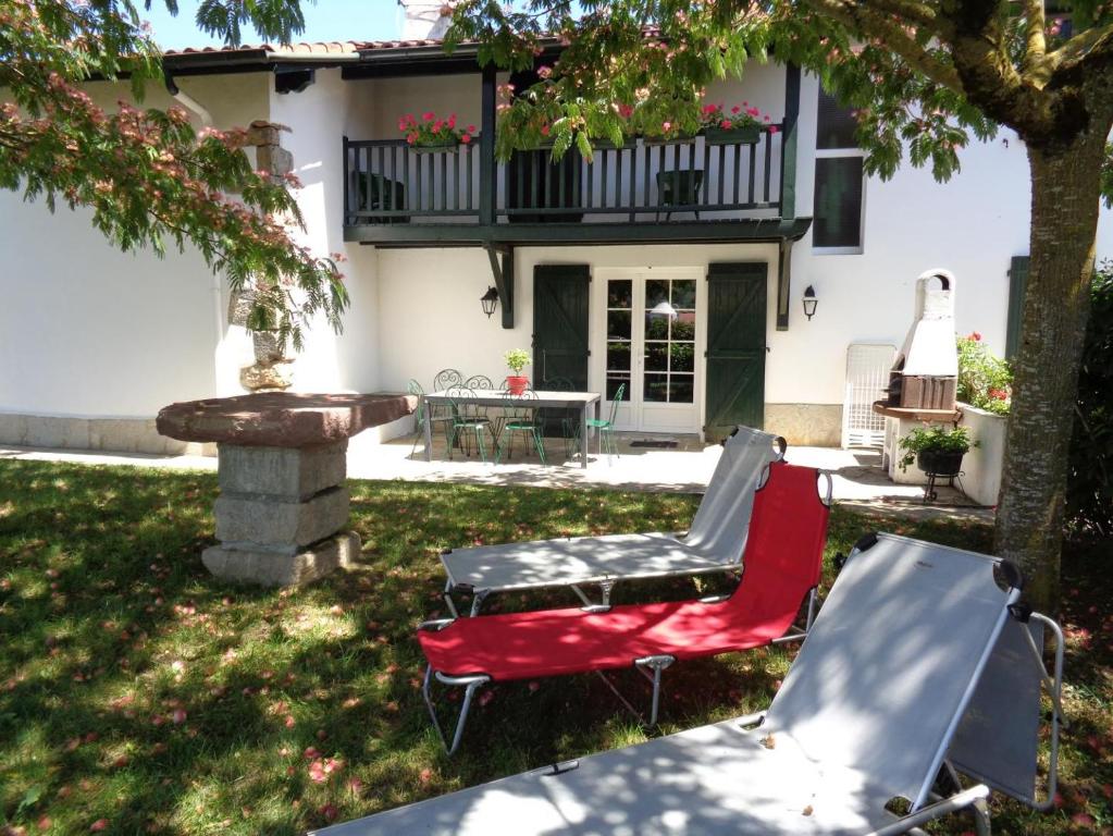 a couple of chairs and a table in front of a house at Maison etxebarnia cote in Mendive