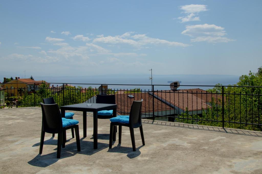 Apartments Teo في أوباتيا: طاولة وكراسي مطلة على المحيط