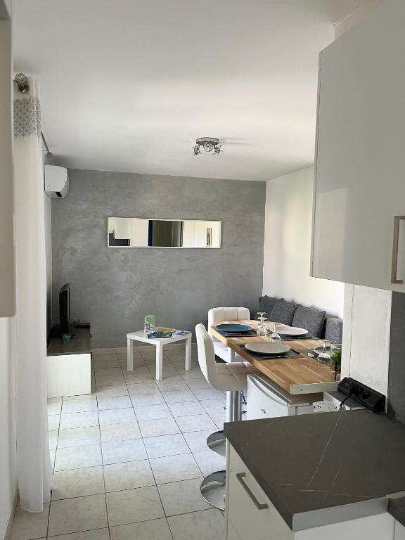 une cuisine et un salon avec une table et des chaises dans l'établissement Appartement cosy, à Six-Fours-les-Plages