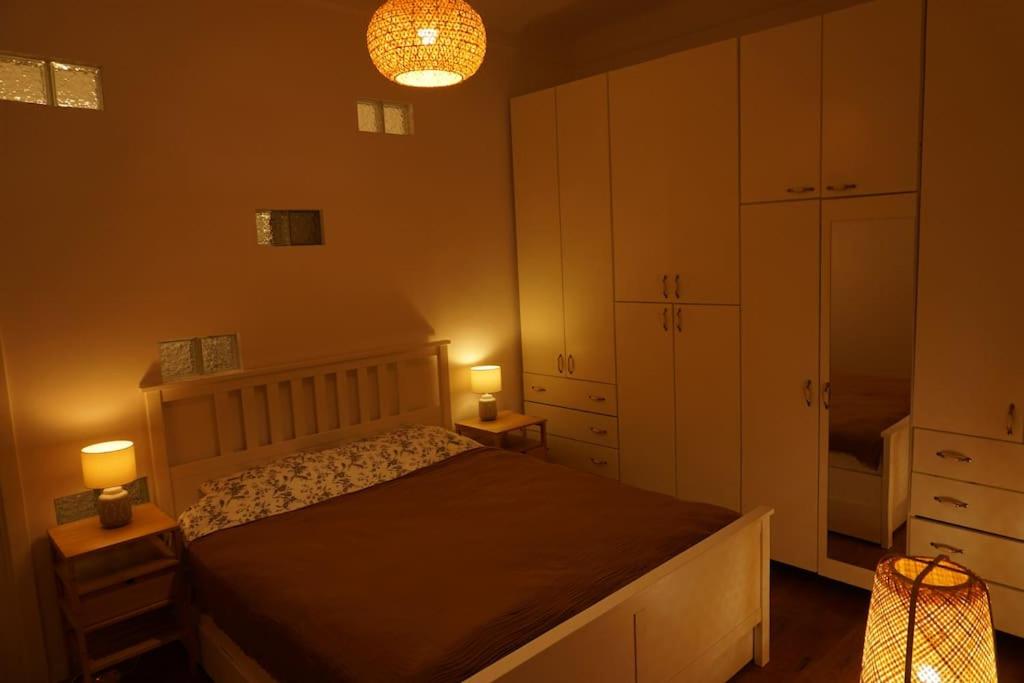 a bedroom with a bed and two lamps on two tables at Central Park Apartment in Cluj-Napoca