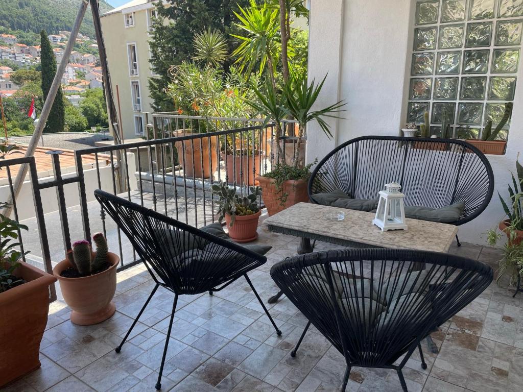 un patio con 2 sillas y una mesa en el balcón en Mavi Apartments, en Dubrovnik