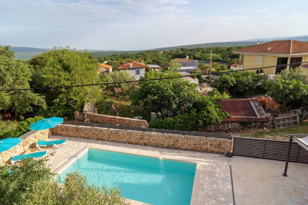 ein Pool mit zwei Sonnenschirmen und ein Haus in der Unterkunft Villa ANNA-LENA with pool close to sandy beach in Garica