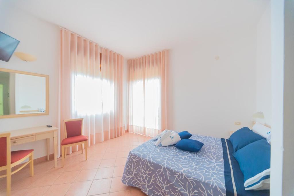 a bedroom with a blue bed and a desk and a desk at Hotel America in Marina di Camerota