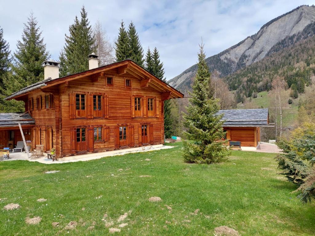 a log cabin in the mountains with a yard at Chez Pierre in Praz-de-Fort