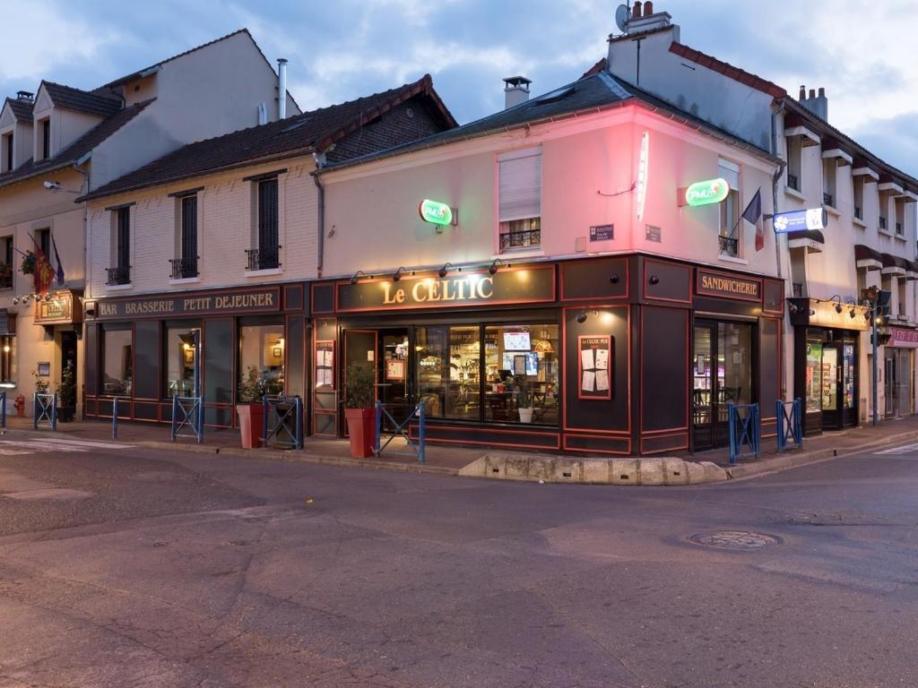 una esquina con una tienda en una calle de la ciudad en Le Celtic, en Le Thillay