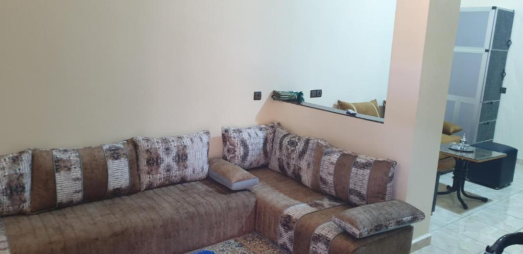 sala de estar con sofá y espejo en APARTAMENTOS NASSIRi, en Laayoune