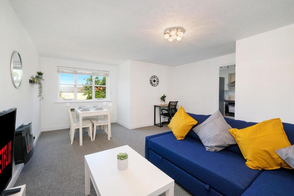 a living room with a blue couch and a table at 2 bed luxury apartment in Enfield