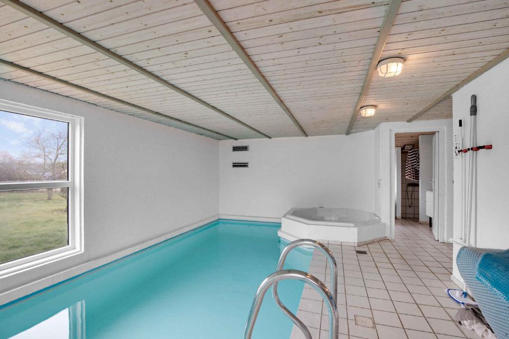 una piscina con bañera en una habitación con ventana en Vandstedet 14, 6430 Nordborg en Nordborg
