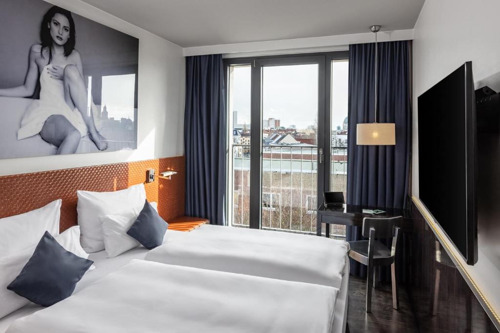 een hotelkamer met een bed en een groot raam bij Hotel MANI by AMANO in Berlijn