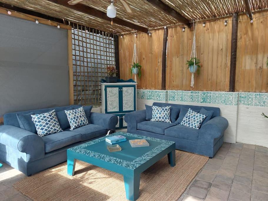 a living room with blue couches and a coffee table at Hide Away on 21 in Mossel Bay
