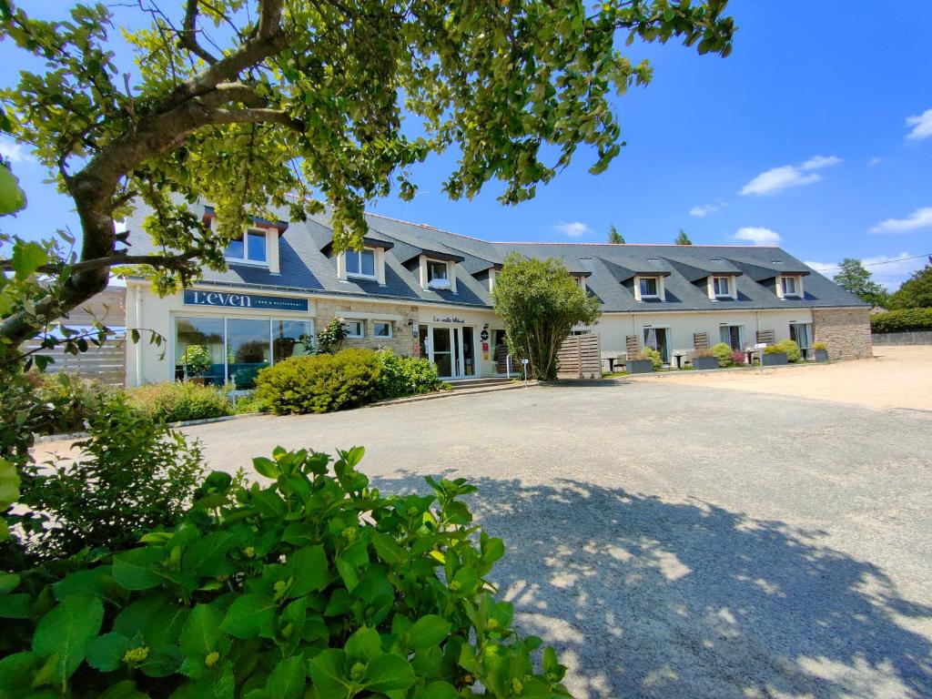 a large building with a driveway in front of it at Hôtel Restaurant La Voile Bleue in Erdeven