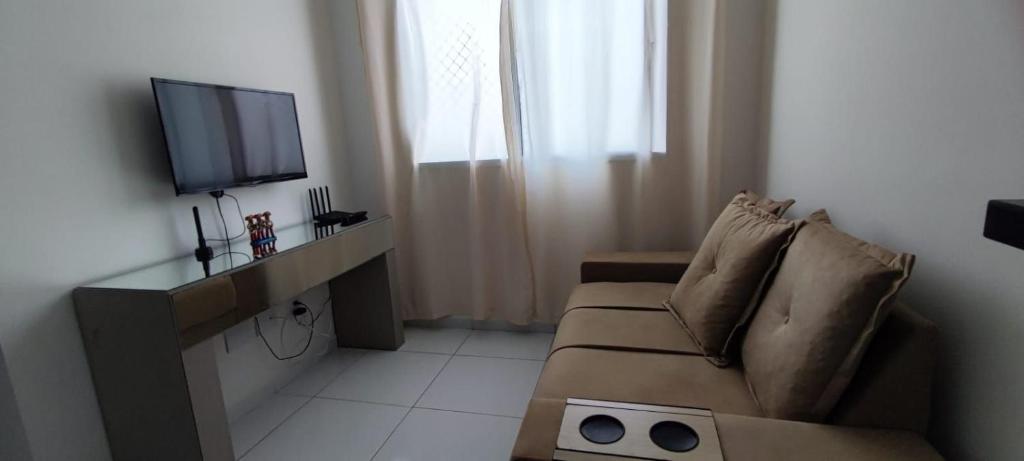 a living room with a couch and a flat screen tv at Ap da Thay - Arretado in Campina Grande