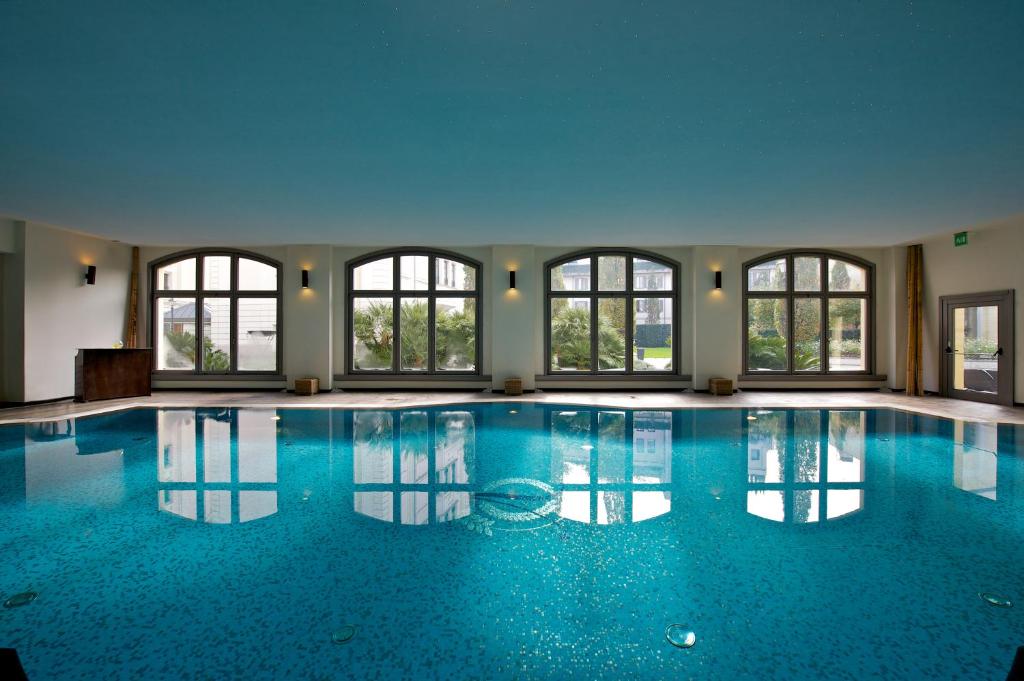 ein großer Pool mit Fenstern in einem Gebäude in der Unterkunft Grand Visconti Palace in Mailand