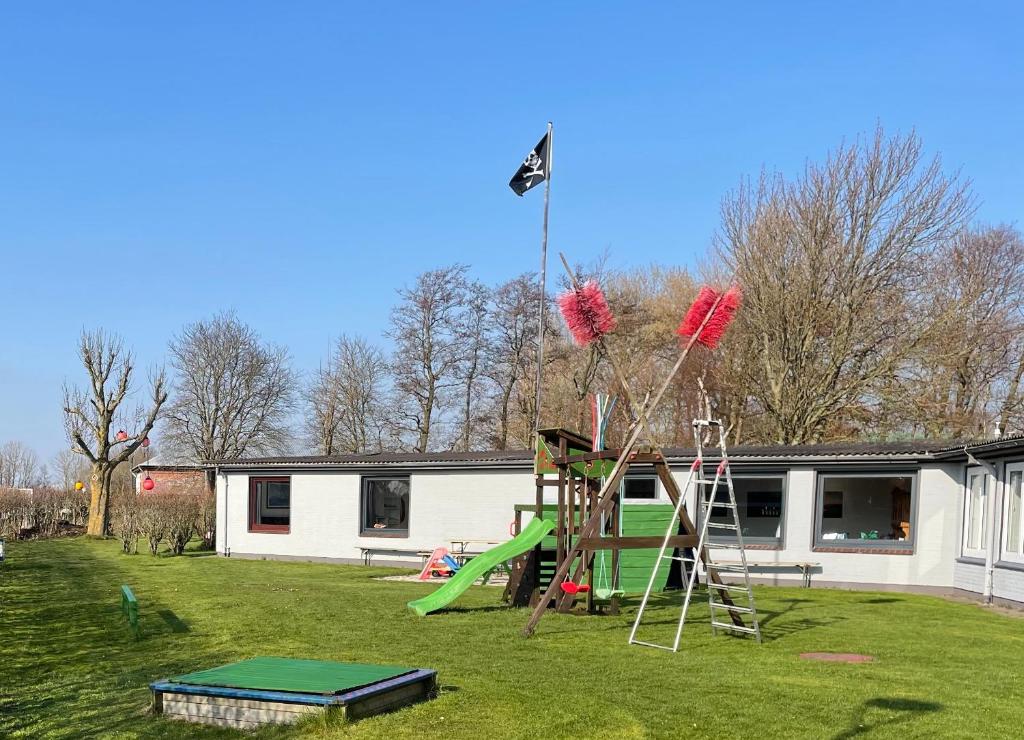 a playground in a yard next to a building at EcoLodge Bungalow in Oesterdeichstrich