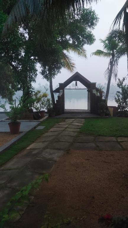 a pathway leading to a house with a view of the ocean at Ambadi's villa -Lake view resort in Pallipuram