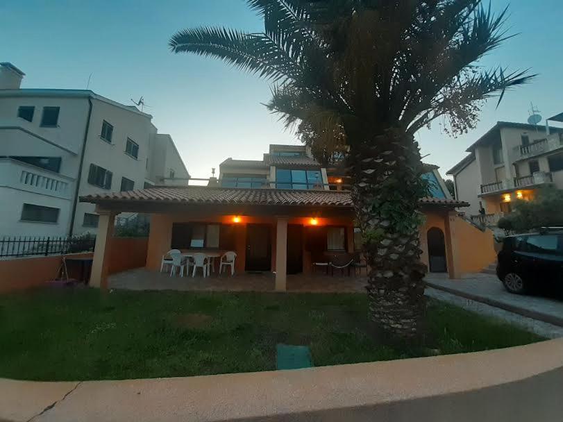 a house with a palm tree in front of it at APARTMANI DELAS in Pješčana Uvala