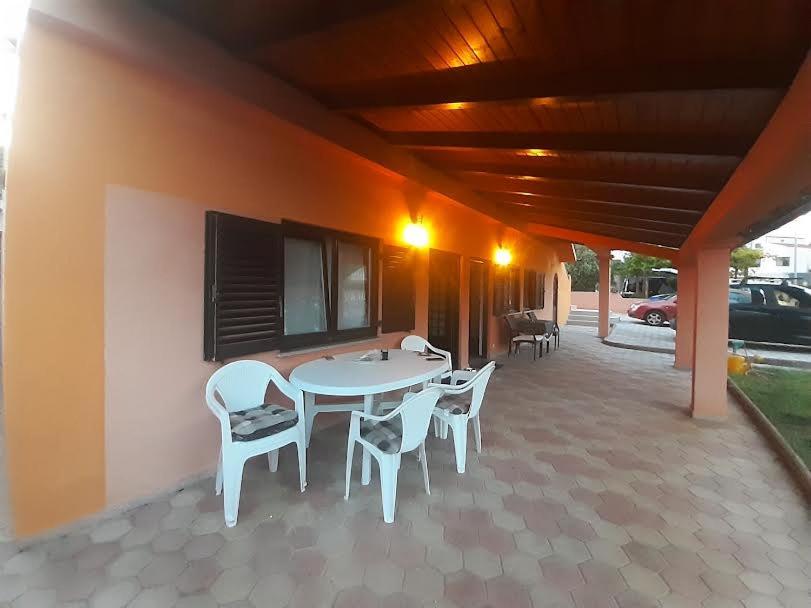 a patio with a white table and chairs on it at APARTMANI DELAS in Pješčana Uvala