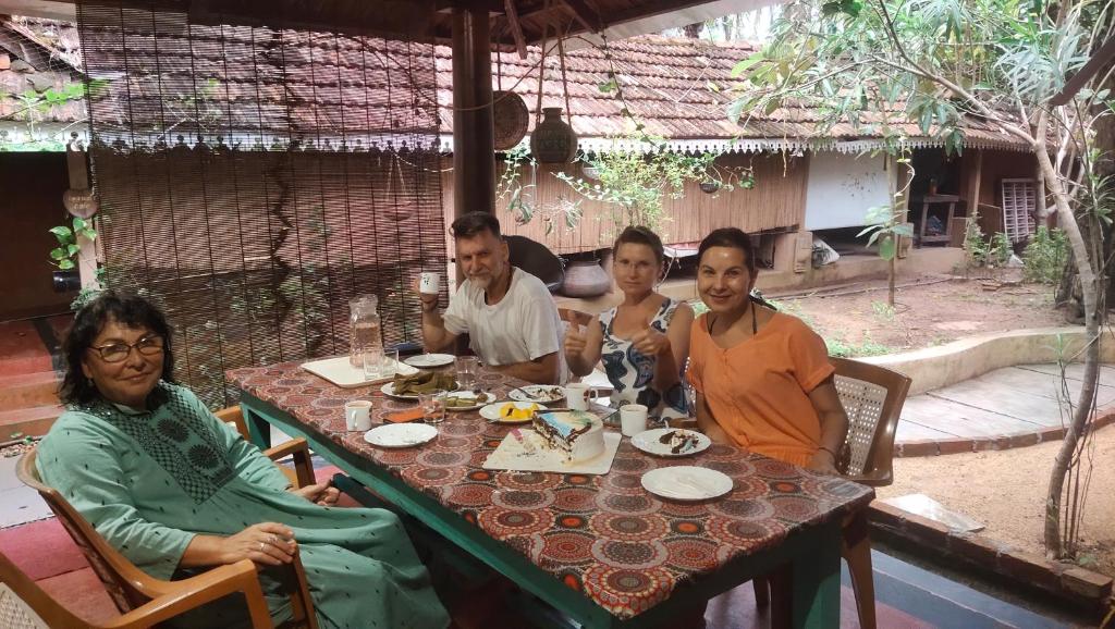 a group of people sitting at a table at Ambadi's villa -Lake view resort in Pallipuram