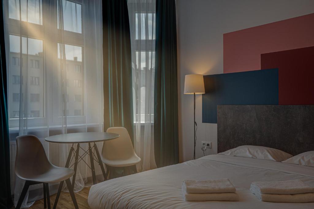 een slaapkamer met een bed en een tafel en stoelen bij Apartamenty Centrum Dworzec PKP self check-in 24h in Katowice