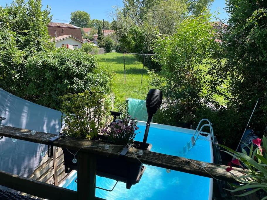 vistas a la piscina desde la terraza de un jardín en Charmante échoppe avec piscine Comme un air de campagne en ville, en Burdeos