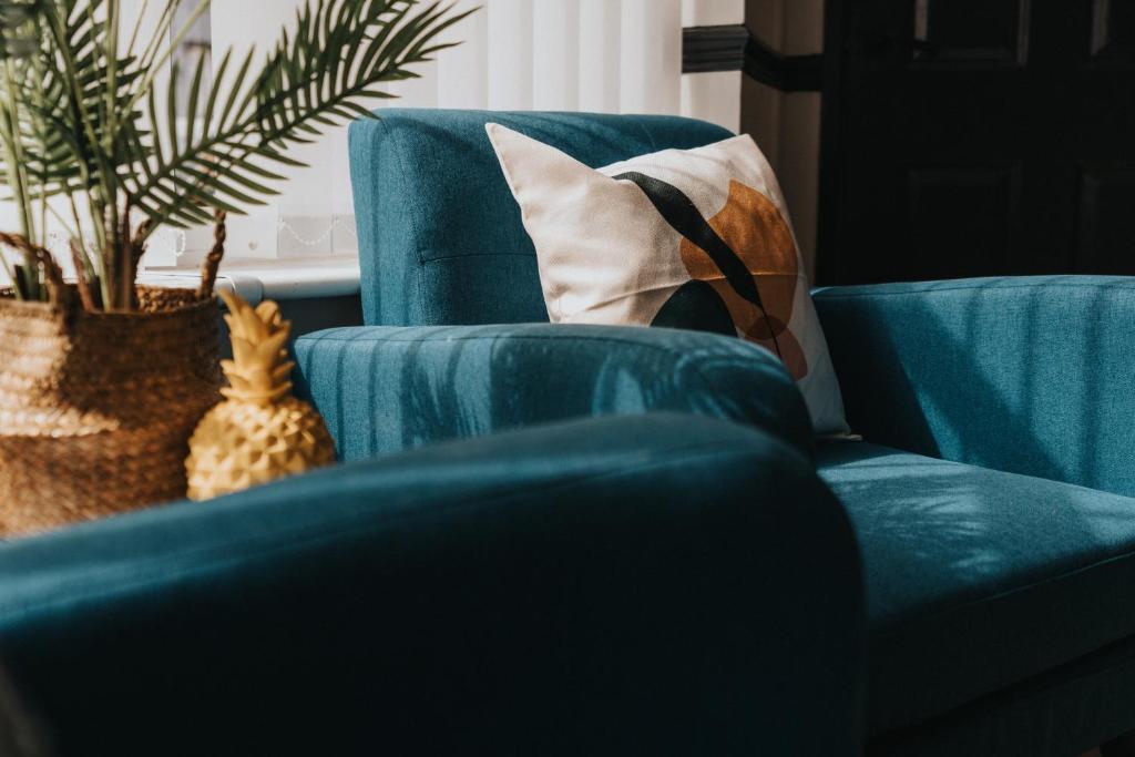una sala de estar con 2 sillas azules y una planta en Orange Rentals- 3 bed Scouse House Sleeps up to 8 guests en Liverpool