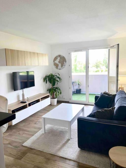 un salon avec un canapé et une table basse dans l'établissement T2 proche de la plage avec stationnement, à Mandelieu-la-Napoule