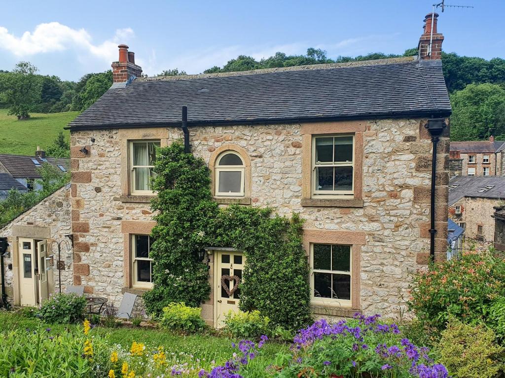 a stone house with ivy growing on it at Penny Cottage in Bonsall