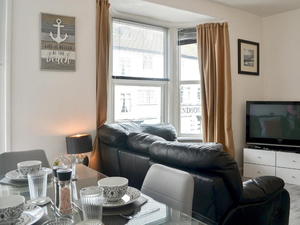a living room with a leather couch and a table at Harbour View - Uk44164 in Bridlington
