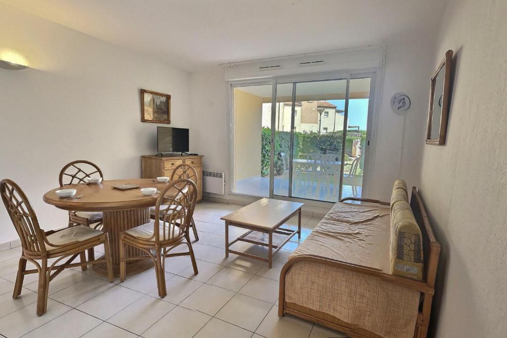 a room with a table and a bed and a dining room at A 50m de la plage, appartement pour 6 personnes avec terrasse in Valras-Plage
