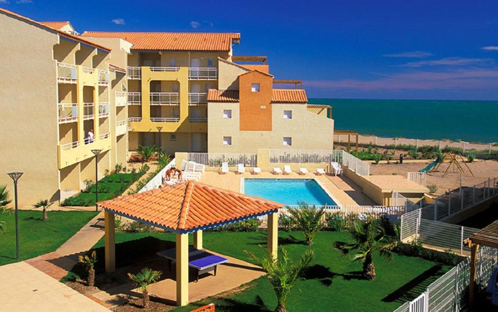 a large building with a swimming pool next to the ocean at A 50m de la plage, appartement pour 6 personnes avec terrasse in Valras-Plage