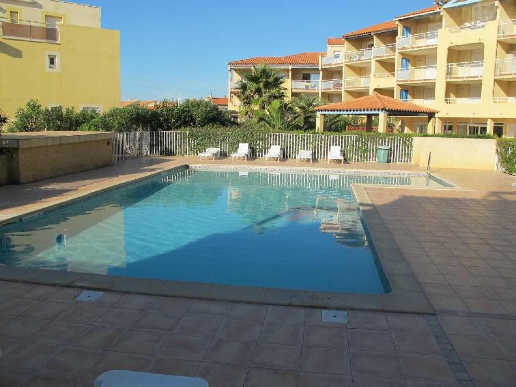 a large swimming pool in front of a building at A 50m de la plage, appartement pour 6 personnes avec terrasse in Valras-Plage