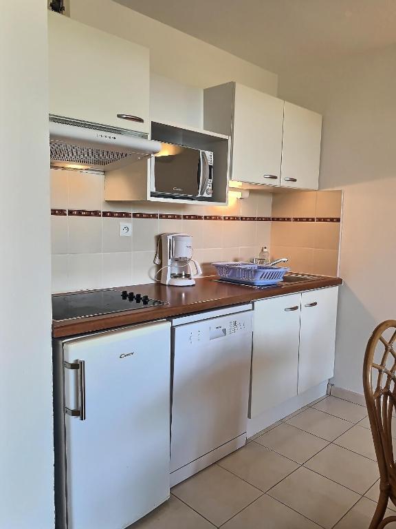 a kitchen with white appliances and a microwave at A 50m de la plage, appartement pour 6 personnes avec terrasse in Valras-Plage