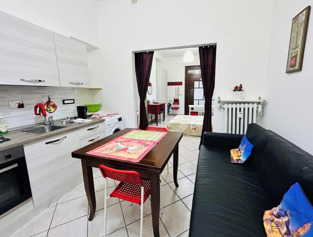 cocina y sala de estar con mesa y sofá. en Monolocale Maria Vittoria, en Turín