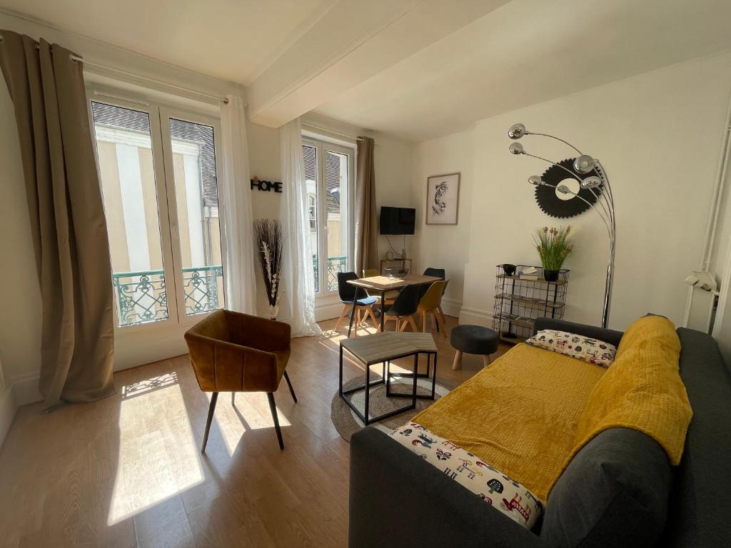 een woonkamer met een bank en een tafel bij Appartement centre ville in Fontainebleau
