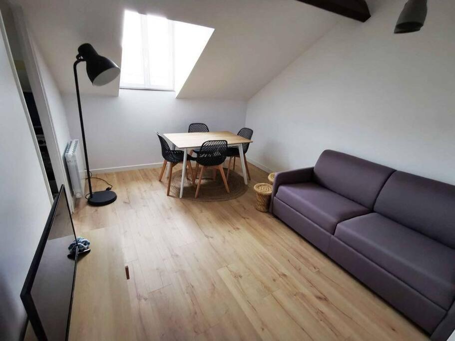 a living room with a couch and a table at Bel Appartement 10mn PARIS in Argenteuil