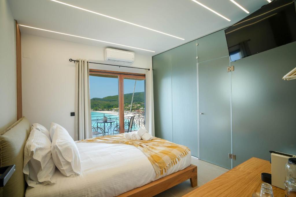 Schlafzimmer mit einem Bett und Blick auf das Wasser in der Unterkunft Omnia Deluxe Rooms in Parga
