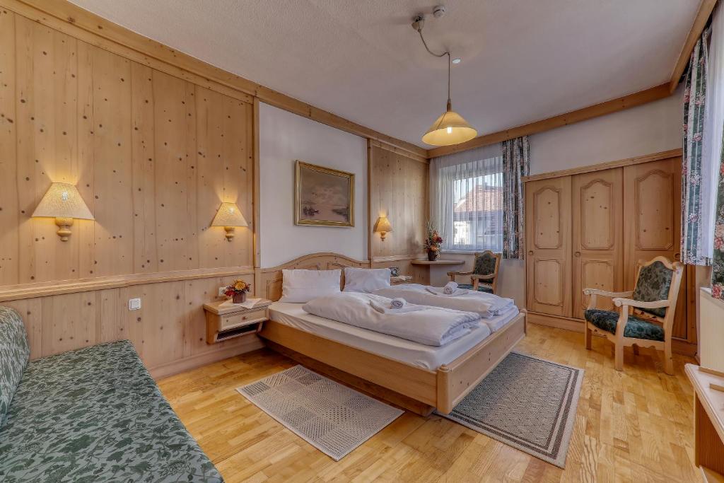 a bedroom with a large bed in a room with wooden walls at Hotel Bayerischer Hof in Bodenmais
