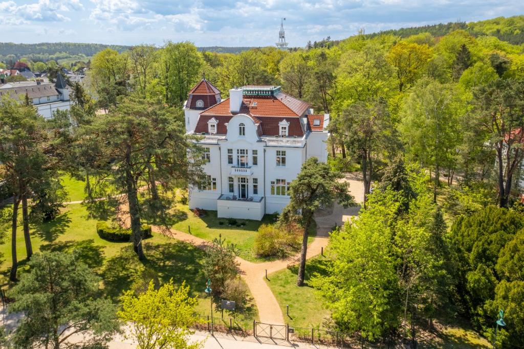 an aerial view of a large white house in the trees at Pineblue Villas in Heringsdorf