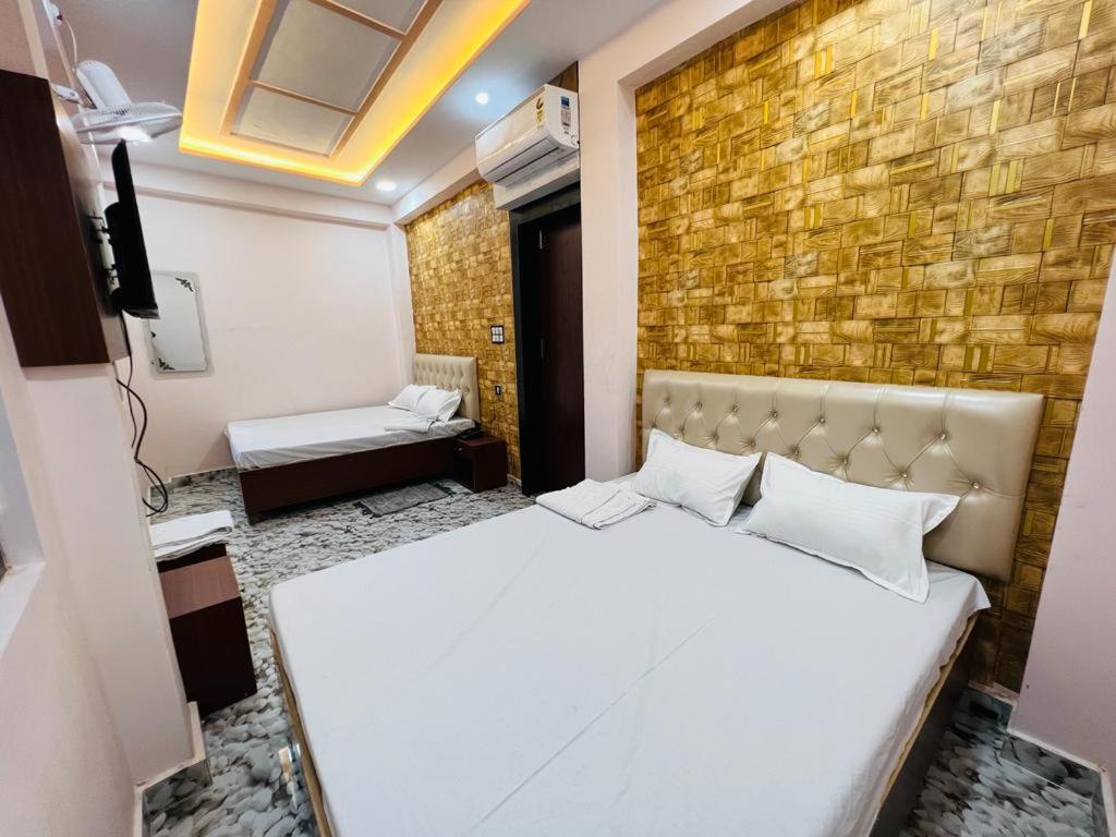 a bedroom with a bed and a brick wall at The Bella Guesthouse in Varanasi