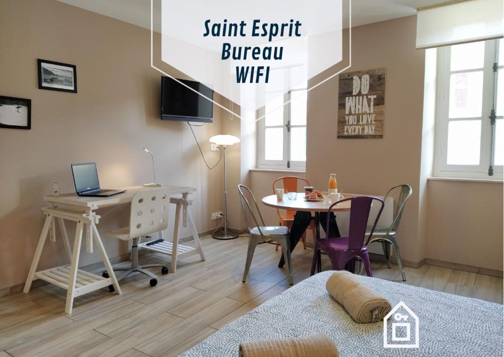 een kamer met een bureau en een tafel met een laptop bij Baiona Sainte Cath -4-Lau- au cœur de Saint Esprit in Bayonne