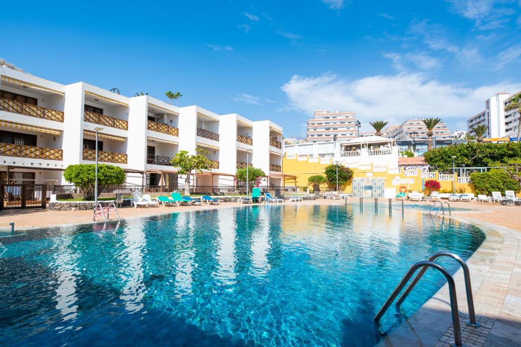 een zwembad in een resort met gebouwen op de achtergrond bij Neptuno Pool and beach private access in Puerto de Santiago